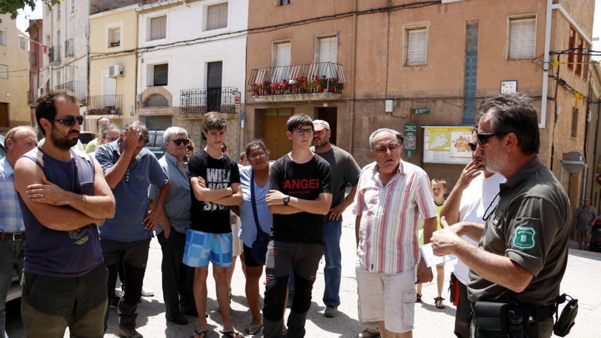 Un agente rural conversando con los vecinos del pueblo de Bovera haciendo el reparto de zonas.