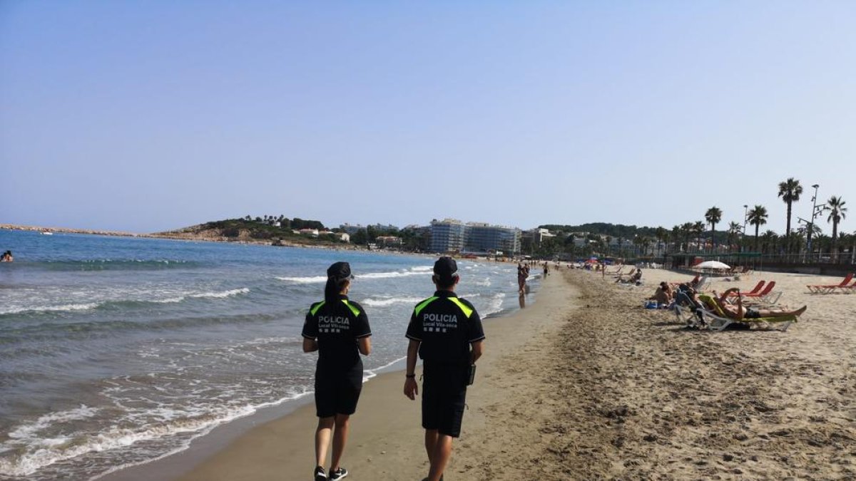 Dos policías patrullando por la playa de la Pineda.