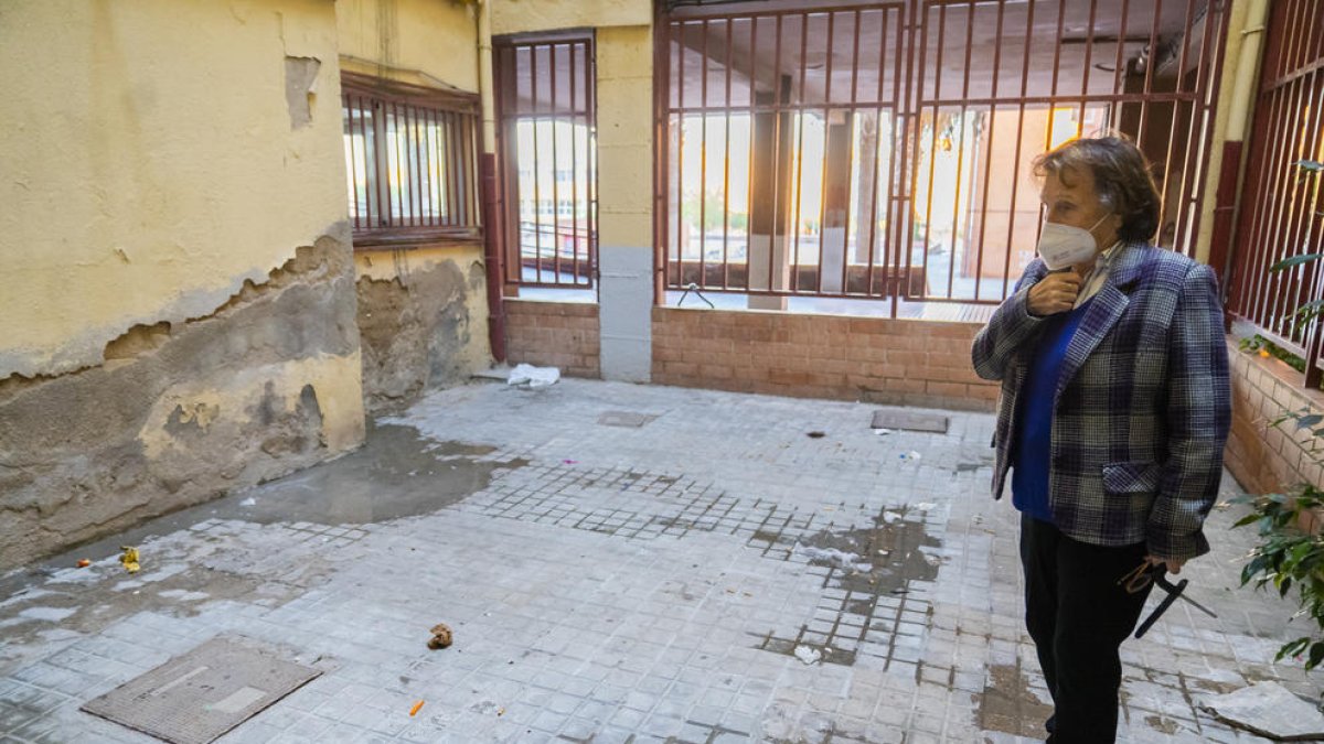 Camacho, presidenta de la comunidad, observando con resignación el mal estado del patio interior de su edificio, propiedad del AHC.