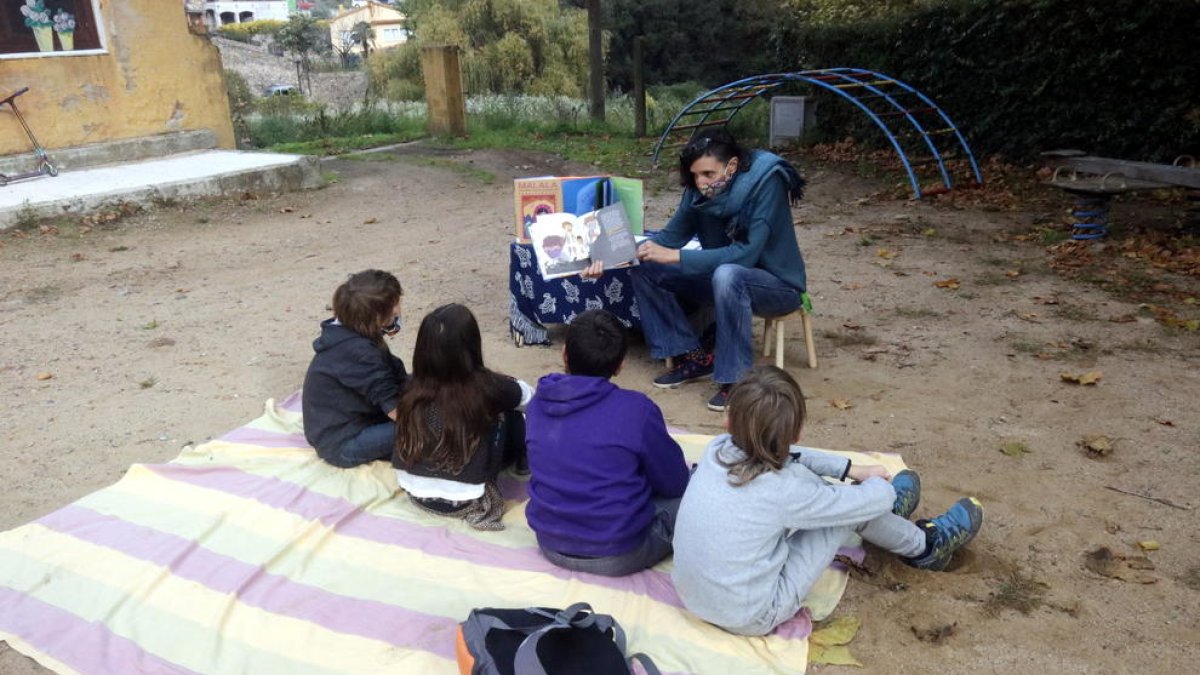 Un grup d'escolars fent classe a un parc infantil públic.