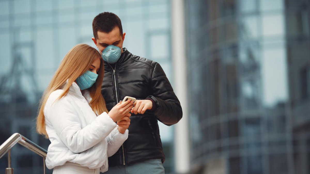 Imatge d'una parella amb mascareta al carrer durant el decret d'alarma pel coronavirus.