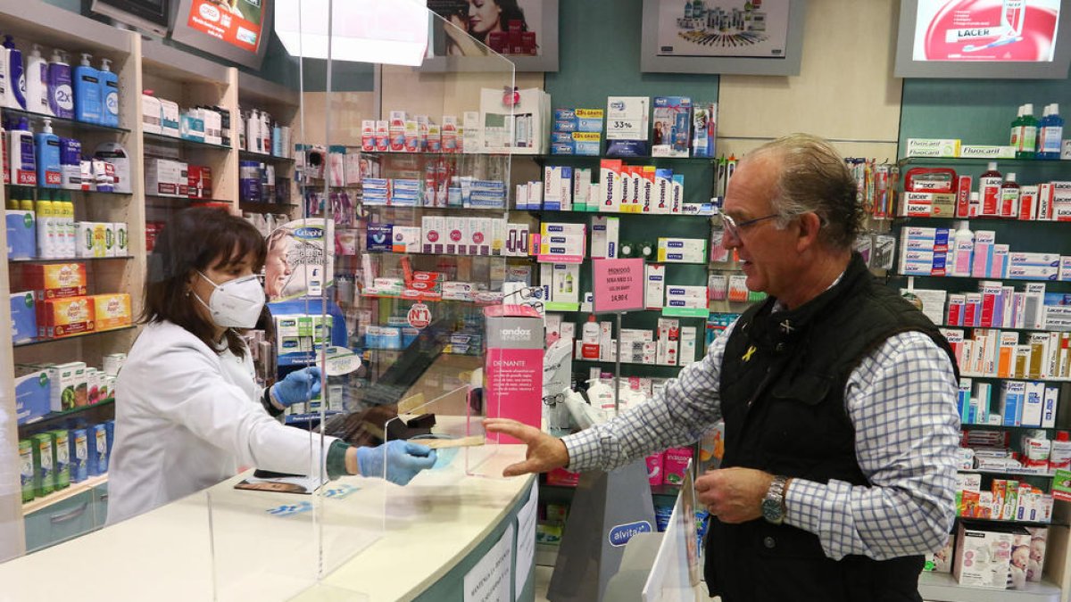 Un hombre adquiere una mascarilla en la Farmacia Ferrús de Reus el 20 de abril.