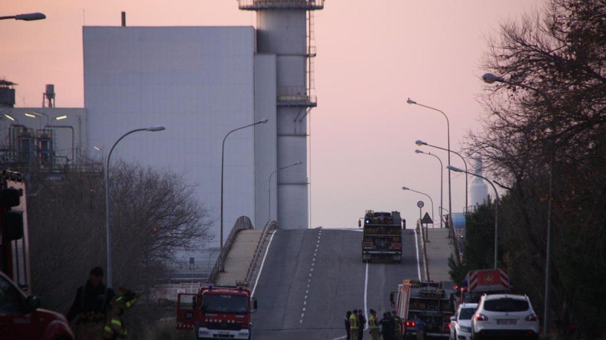 Pla general de l'entrada a la planta d'IQOXE a la Canonja, amb diversos camions de Bombers entrant i sortint.