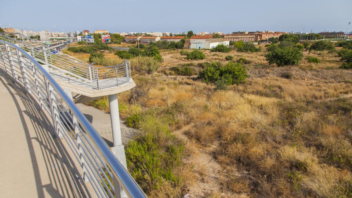 Terrenys que s'han d'urbanitzar per construir un nou centre comercial i habitatges.