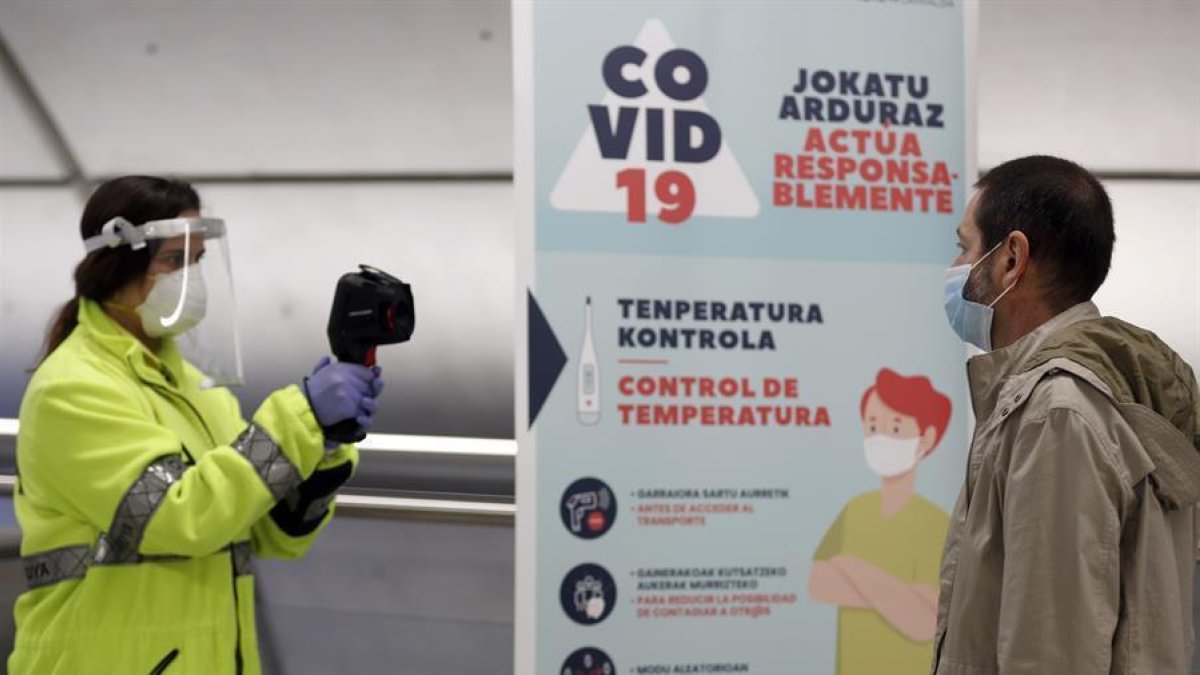 Una voluntària de la DYA pren la temperatura al metro de Bilbao.