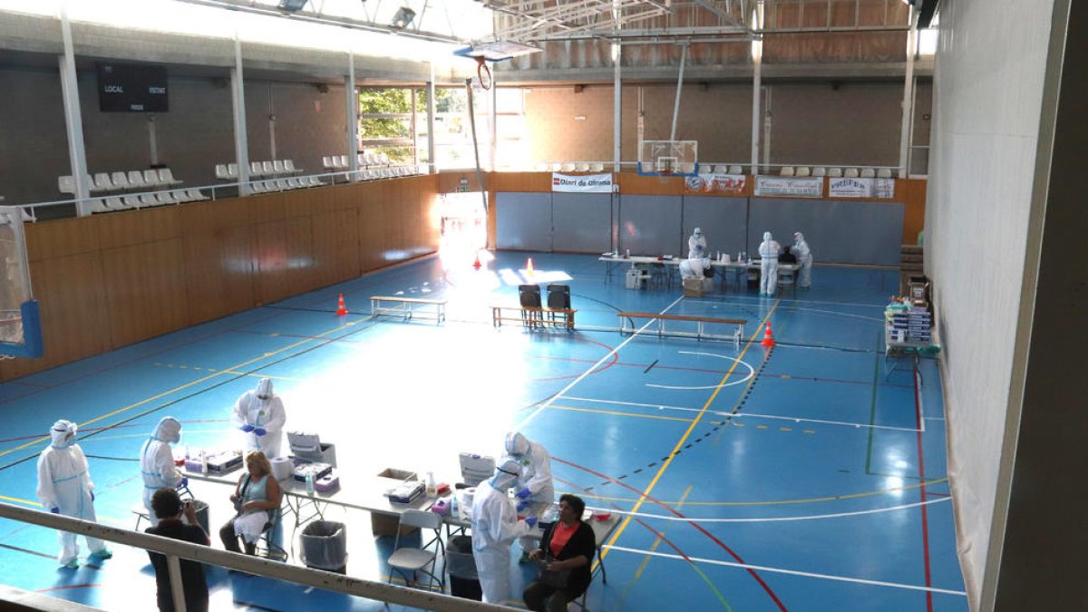 Pla general del personal sanitari fent proves PCR en el primer dia del cribratge massiu al pavelló de Santa Eugènia