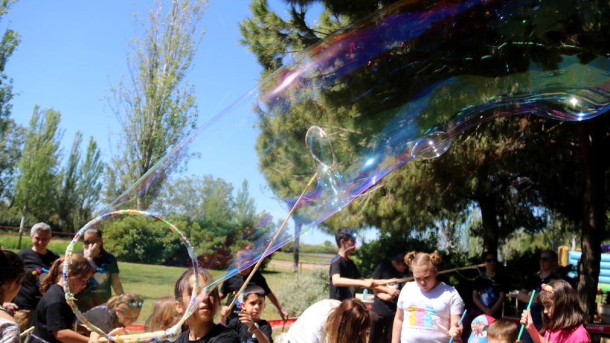 Pla general de diversos infants jugant amb bombolles de sabó a la Festa Esplai.