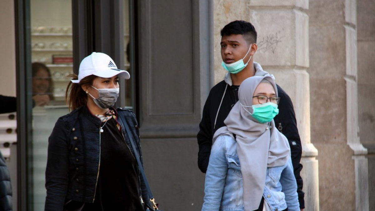 Ciudadanos paseando por las calles del centro de Barcelona con mascarillas