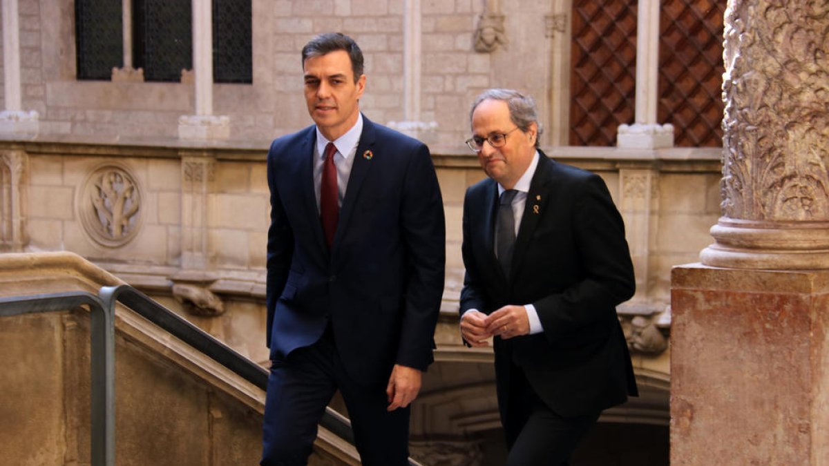 El presidente de la Generalitat, Quim Torra, y el jefe del gobierno español, Pedro Sánchez, antes de reunirse en Palau.