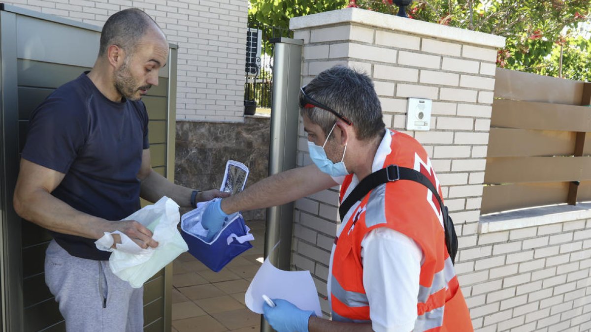 Un instant del repartiment d'ahir, amb un pacient i el voluntari.