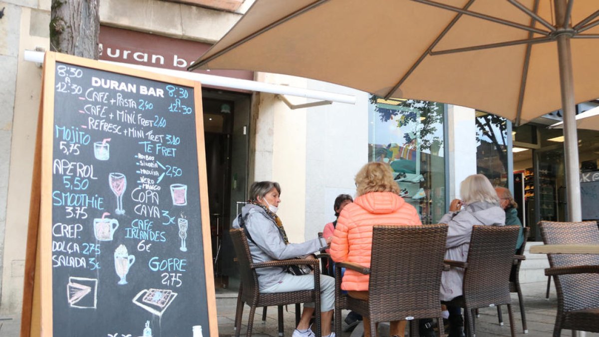 Un grup de persones consumint en una terrassa a Girona.