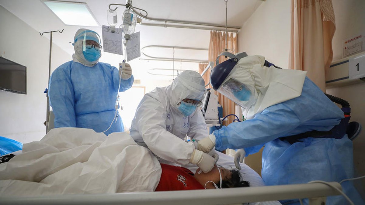 Personal médico tratando un paciente afecatt por COVID-19 en un hospital de Wuhan.