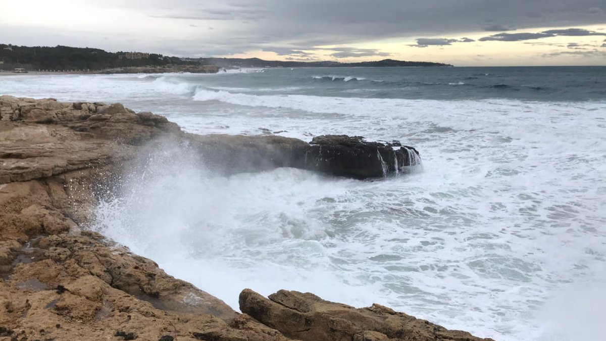 Pla general de les onades impactant contra les roques, a prop de la platja de l'Arrabassada.
