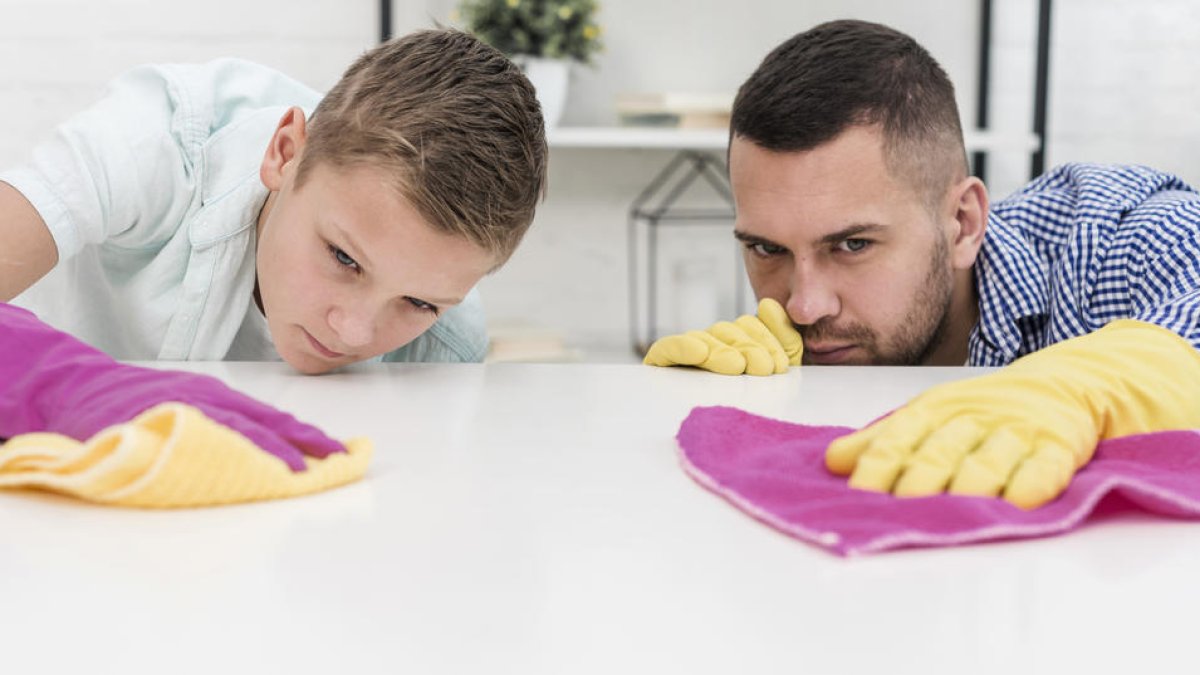 Imagen de un padre y un hijo limpiando una superficie.