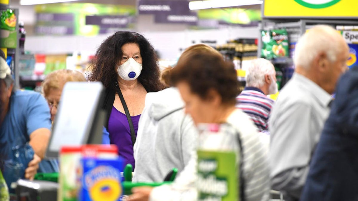 Imatge d'arxiu d'una dona a un supermercat d'Austràlia amb mascareta.