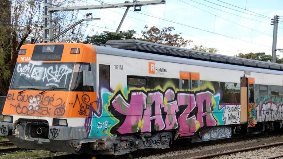 Cabecera del vagón de un tren de Rodalies lleno de pintadas.