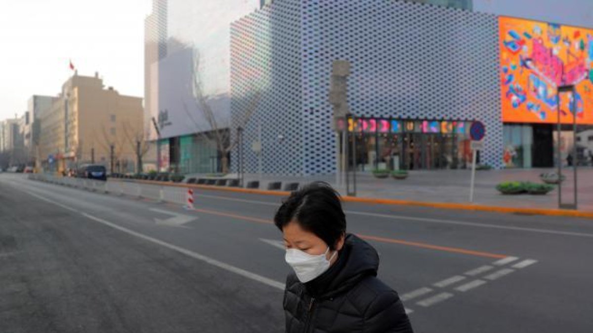 Una mujer en una calle vacía después de la cancelación de las celebraciones de Año Nuevo en Pekin.