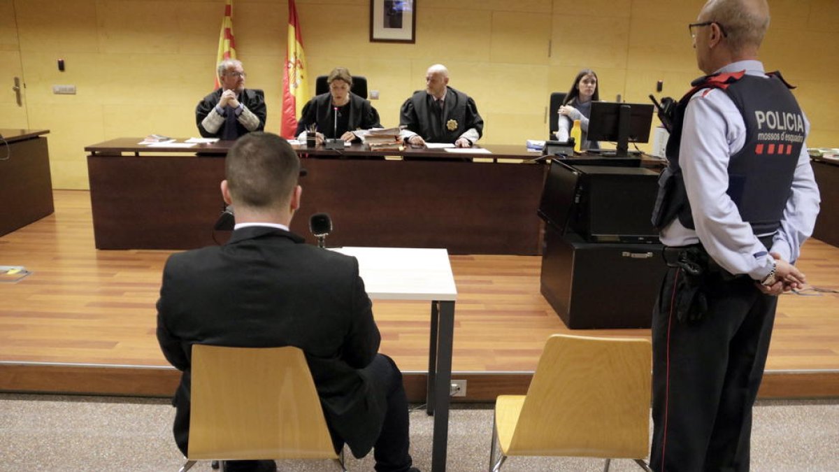 De espaldas, el acusado de intentar asesinar a una mujer y sus hijos en Banyoles.