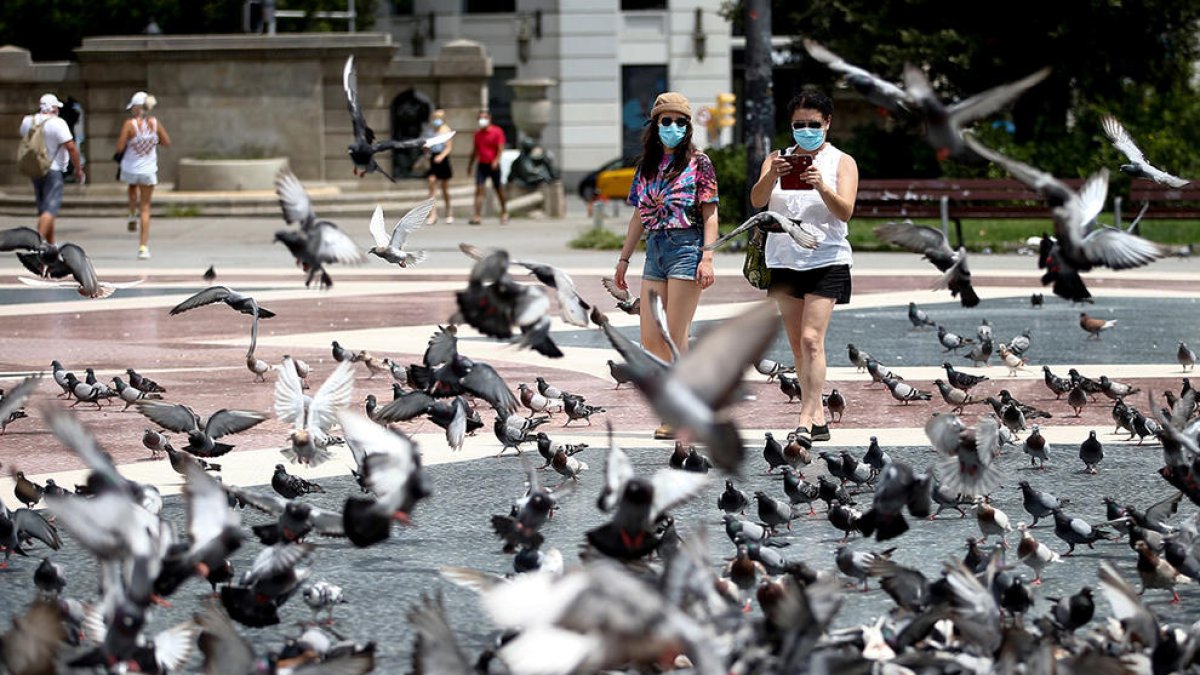 Turistas paseando por la plaza Cataluña de Barcelona.