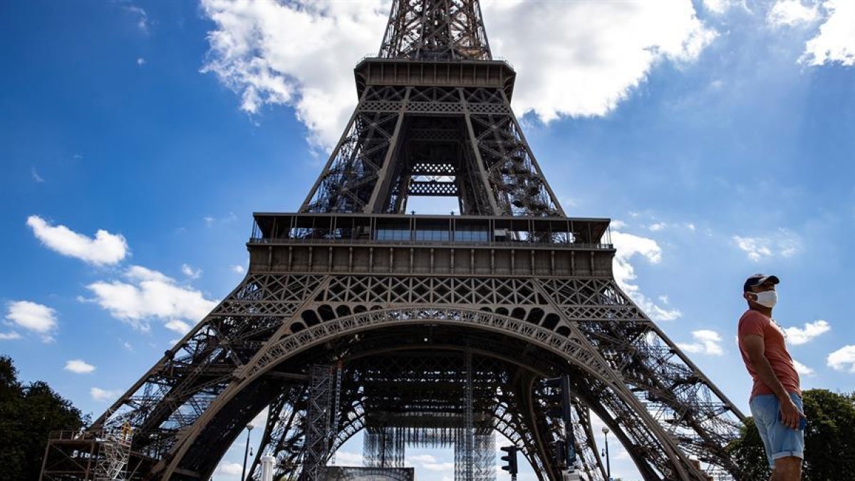 Un home davant la Torre Eiffel.