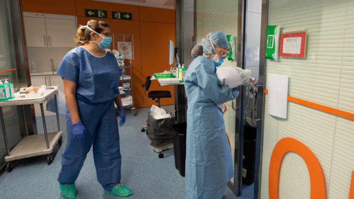 Una professional sanitària entra en una habitació ocupada per un positiu per coronavirus a l'Hospital Clínic.