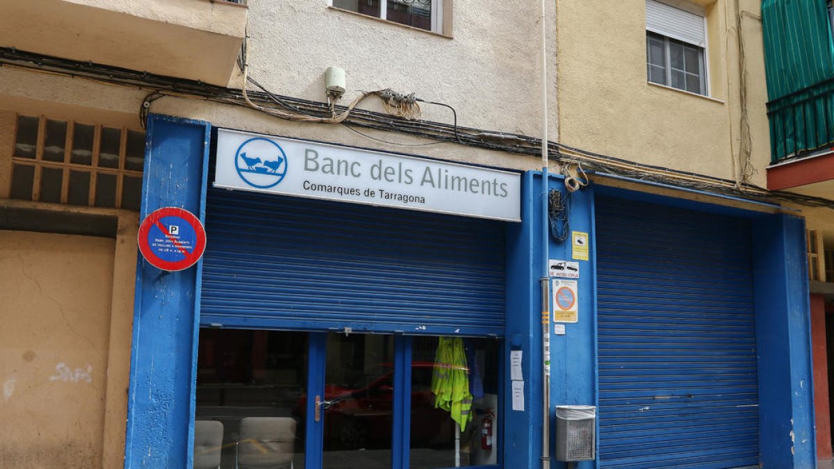 El local de la calle Escultor Rocamora de Reus tiene la persiana a medias y carteles con el nuevo horario.