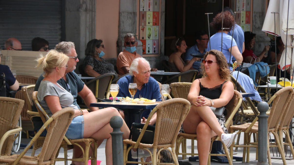 Un grup de persones prenen una cervesa en una terrassa