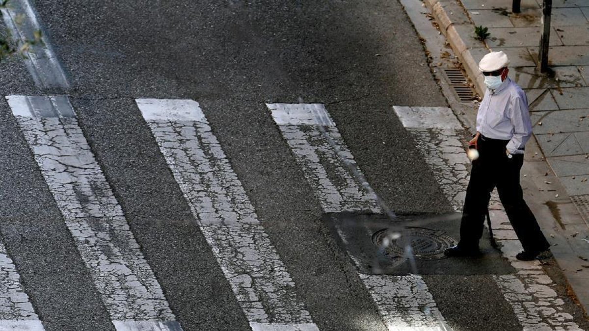 Una persona gran passejant pel carrer.