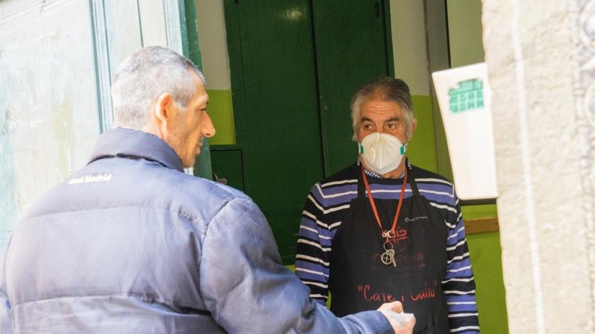 Un usuari ahir, agafant el menjar oferit per Càritas, en el programa Cafè i Caliu.