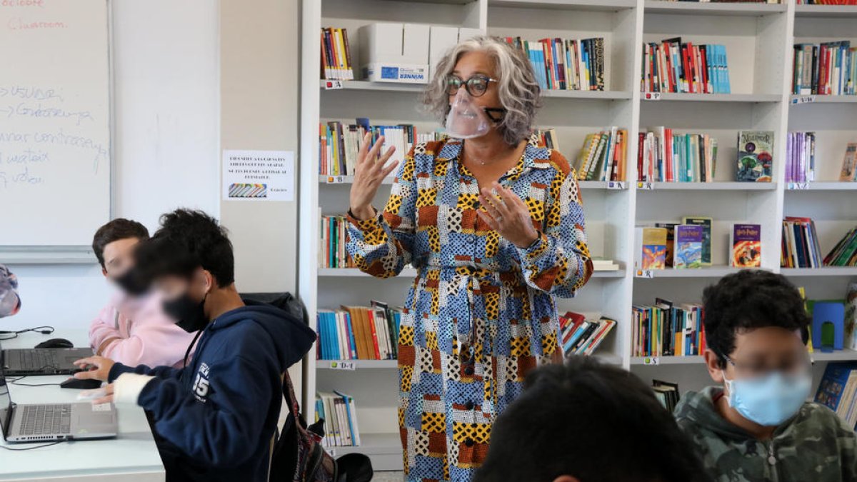 Una profesora del INS Andreu Nin del Vendrell impartiendo clase mientras utiliza una mascarilla transparente.