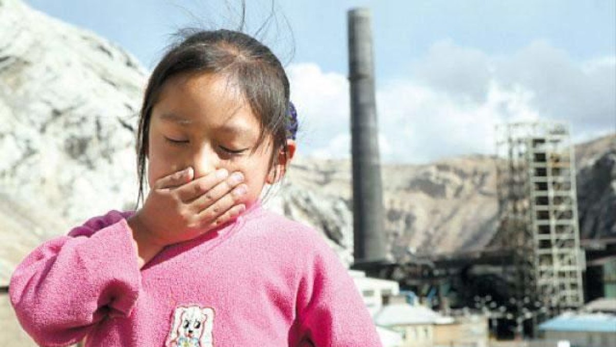 Imagen de un niño al lado de una instalación industrial.