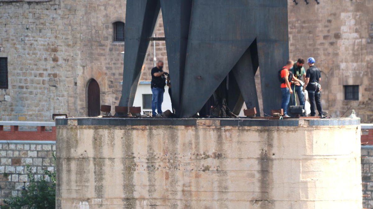 Pla general d'alguns agents dels Mossos d'Esquadra fent una inspecció ocular sobre l'explosió a la base del monument franquista de l'Ebre a Tortosa.