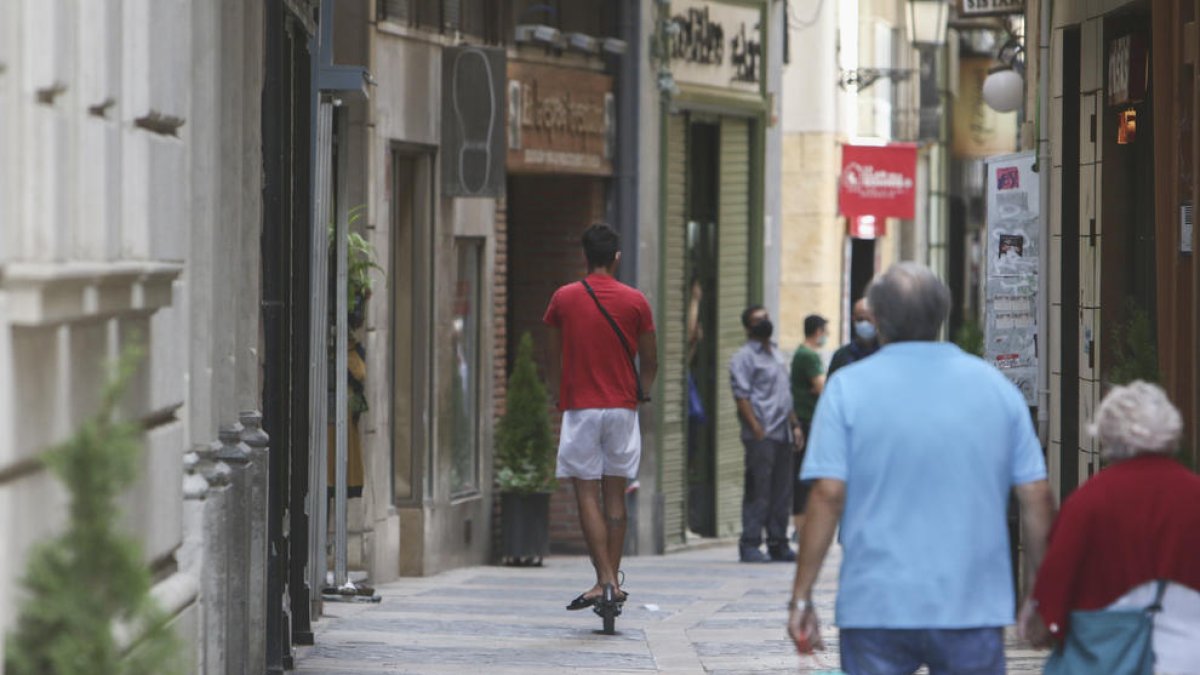 Una persona en patinet al carrer de les Galanes.