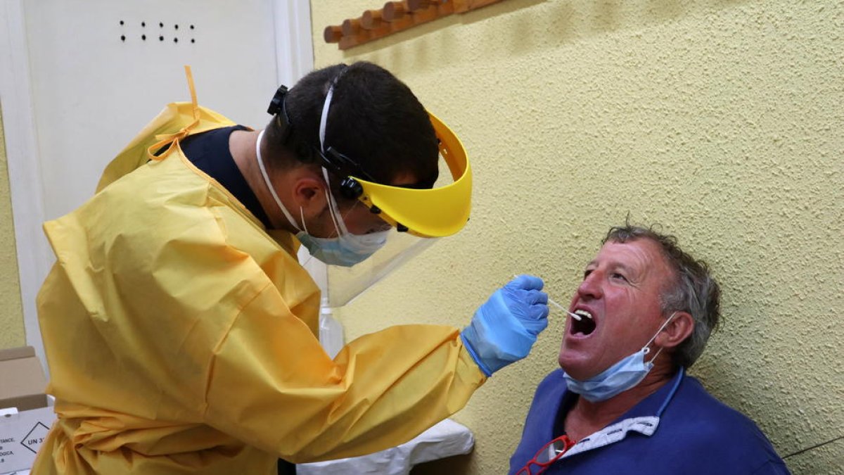 Un profesional sanitario haciendo una prueba de covid-19 a una persona en el cribado llevado a cabo en Puigcerdà.