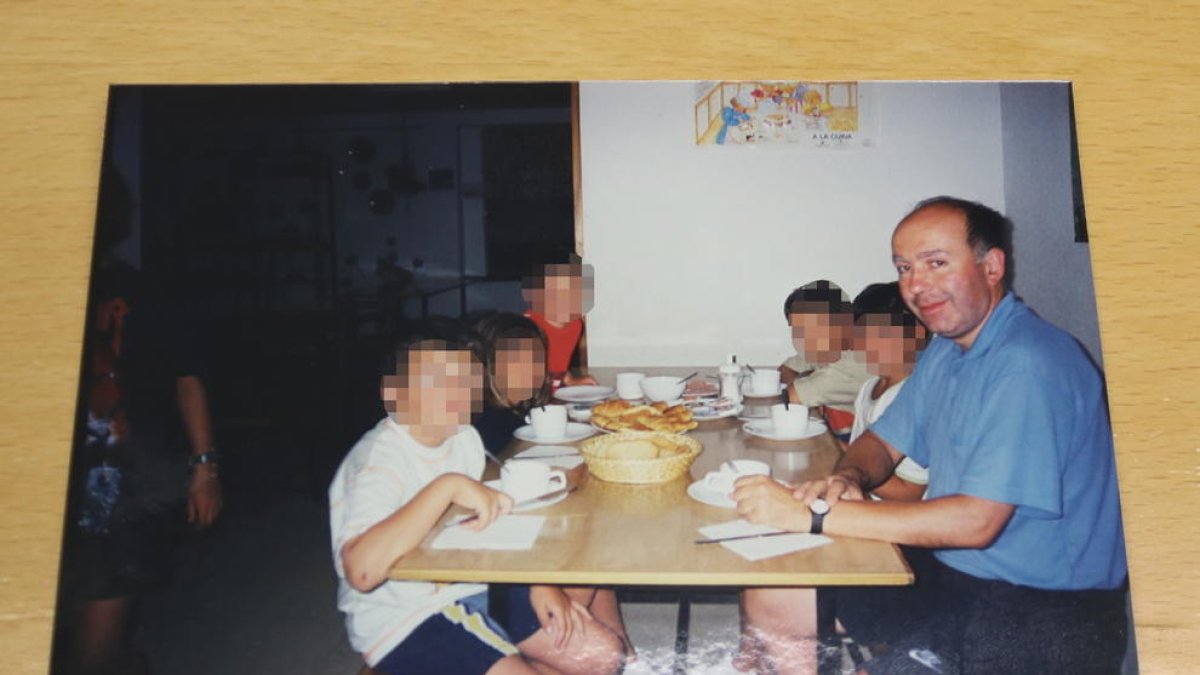 Una fotografía del mosén Josep Maria Font de colonias con varios niños, con la cara pixelada.