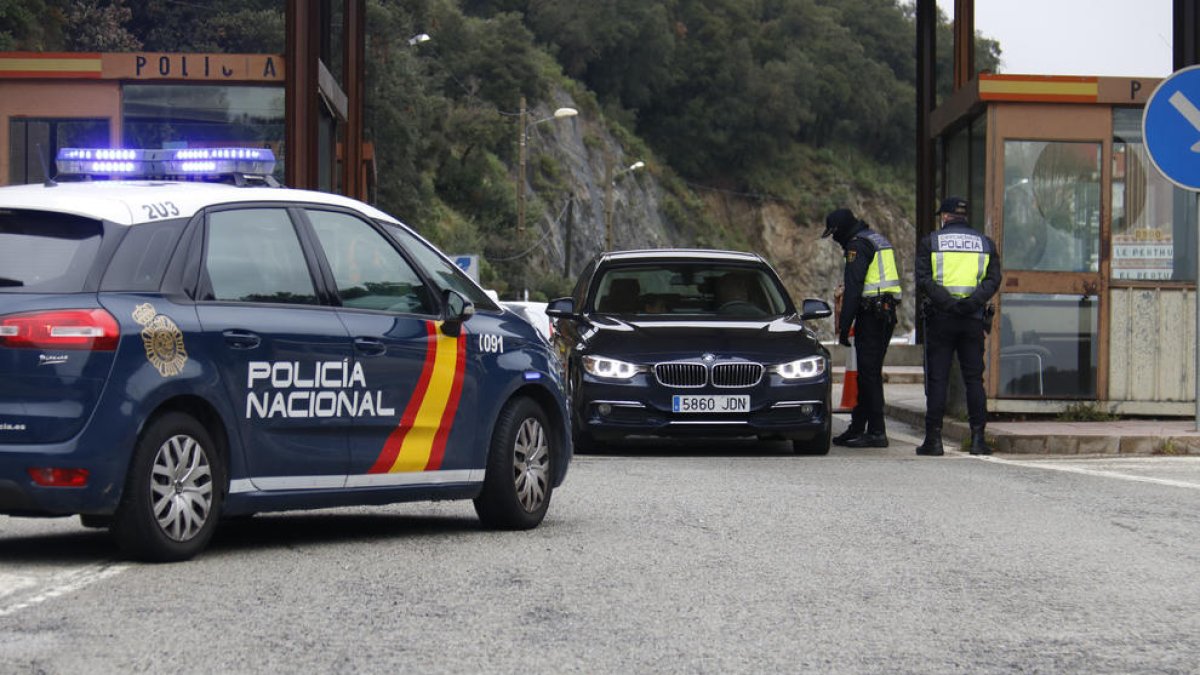 Dos agents de la Policia Nacional fent un control en un turisme espanyol que vol creuar la frontera al Pertús.