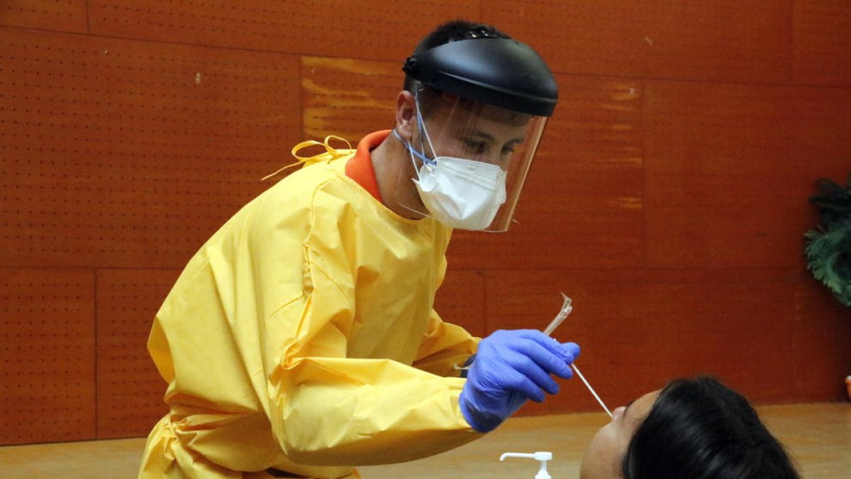 Un sanitari fent una prova PCR a un veí del barri de Balàfia de Lleida en el marc del cribratge massiu.