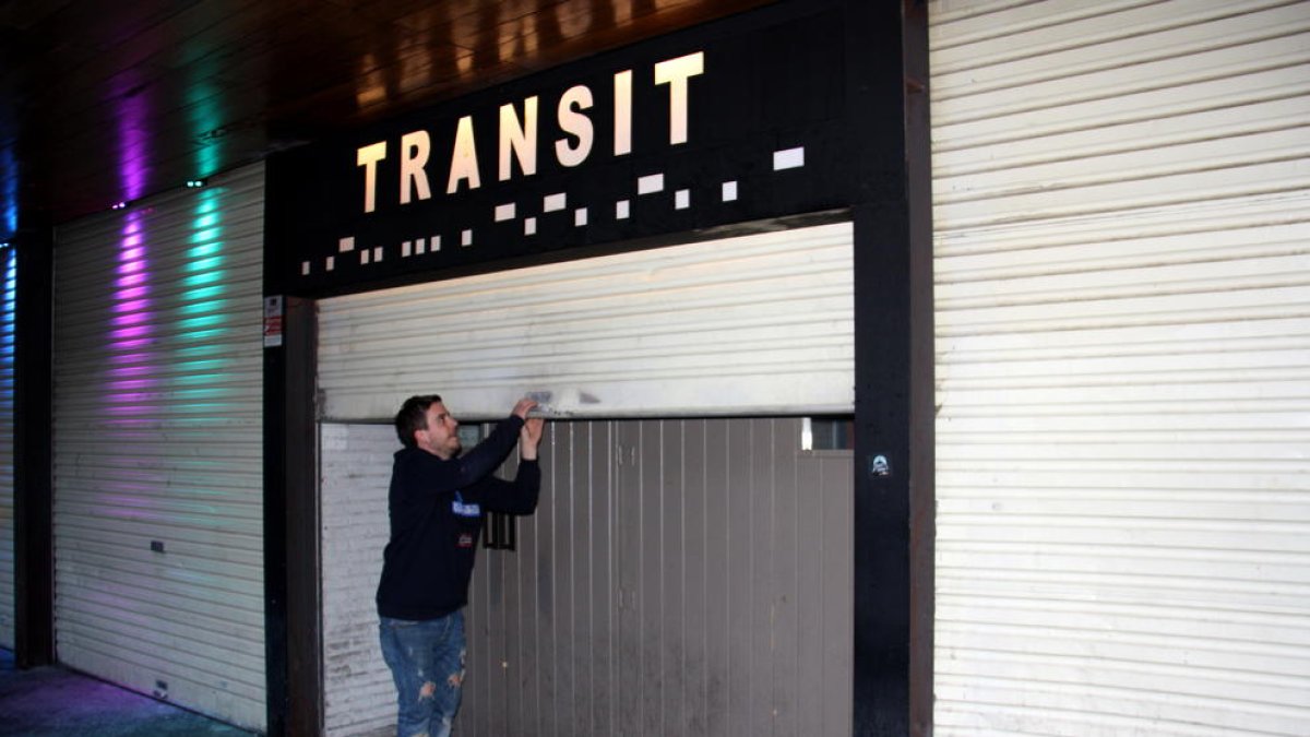 El gerent de la discoteca-pub Trànsit de Puigcerdà, Igor Roig, abaixant la persiana del seu local.