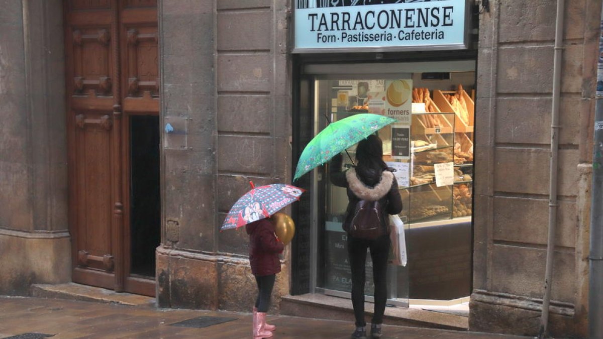 Una dona i una nena, a punt d'entrar en una pastisseria del carrer Comte de Rius de Tarragona.