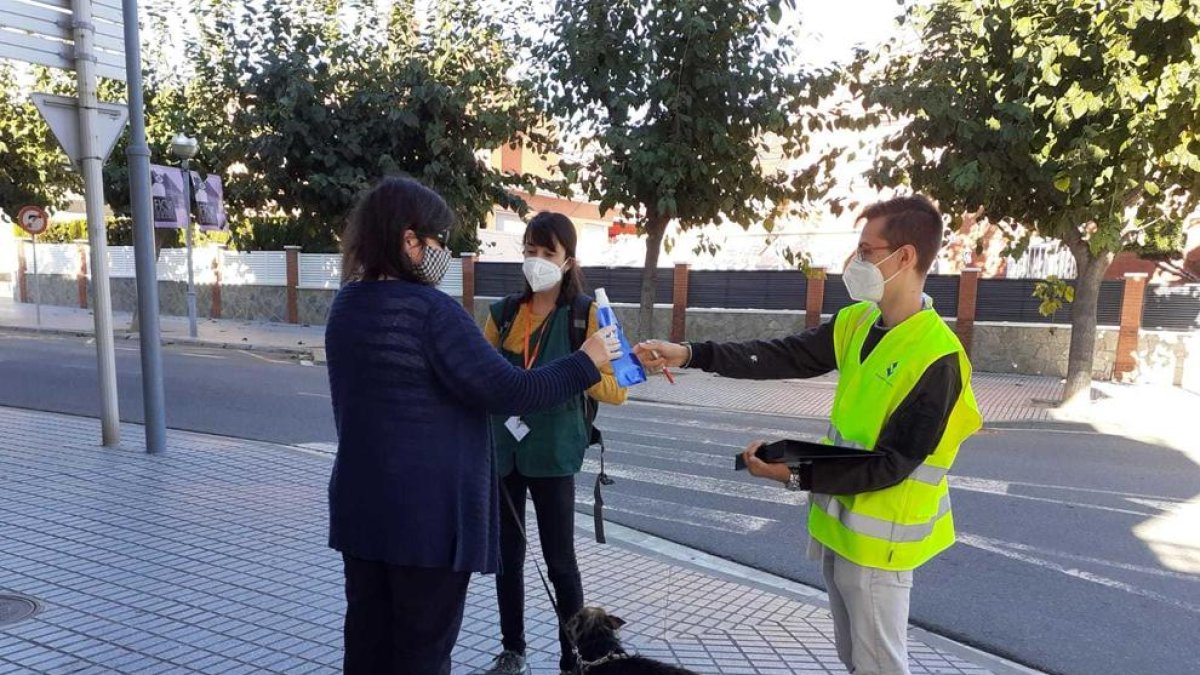 Dos agents cívics informant a una dona amb el seu gos.