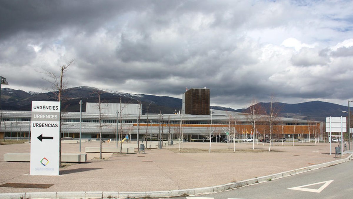 Exterior del edificio del Hospital de Cerdanya, donde se ve en primer término un cartel que indica dónde está la zona de Urgencias.