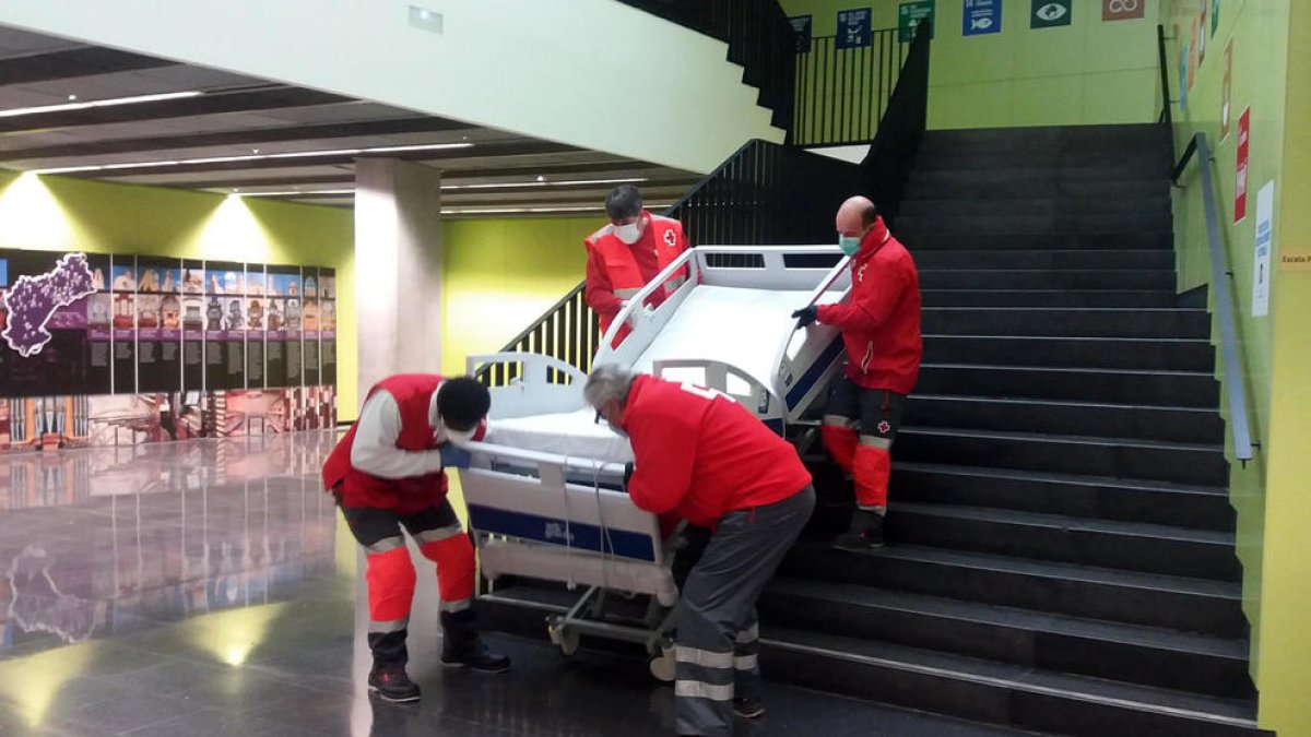 Efectius de Creu Roja baixant un llit de la Facultat d'Infermeria de la URV.