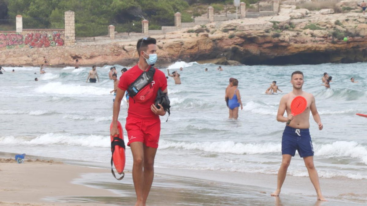 Pla sencer d'un socorrista de Creu Roja Tarragona passejant per la platja de l'Arrabassada