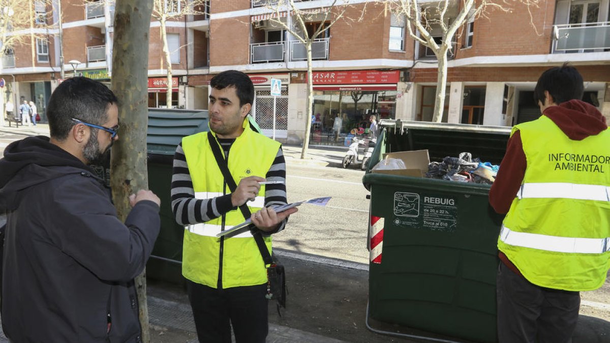 Un equipo informa a los que se acercan con la basura sobre cómo se tienen que separar y depositar los residuos.