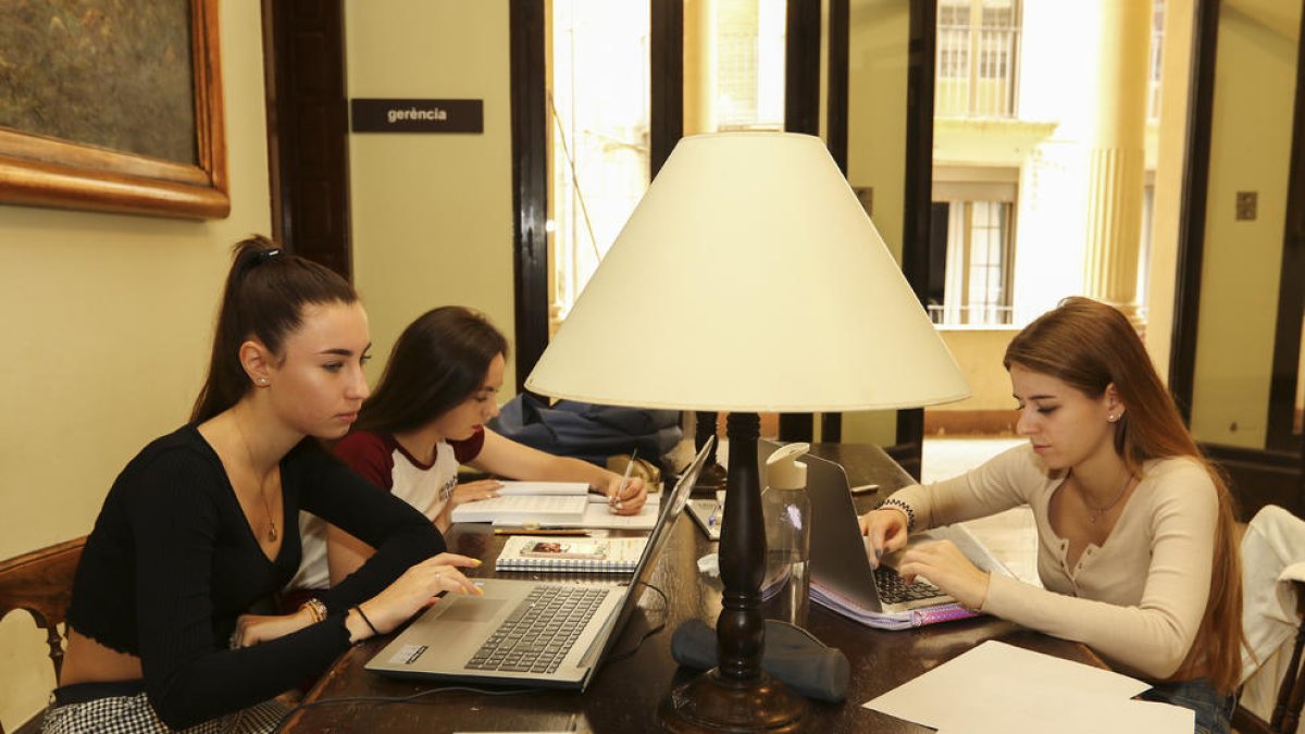 Tres estudiants utilitzant l'ordinador a l'interior d'un dels espais del Centre de Lectura.