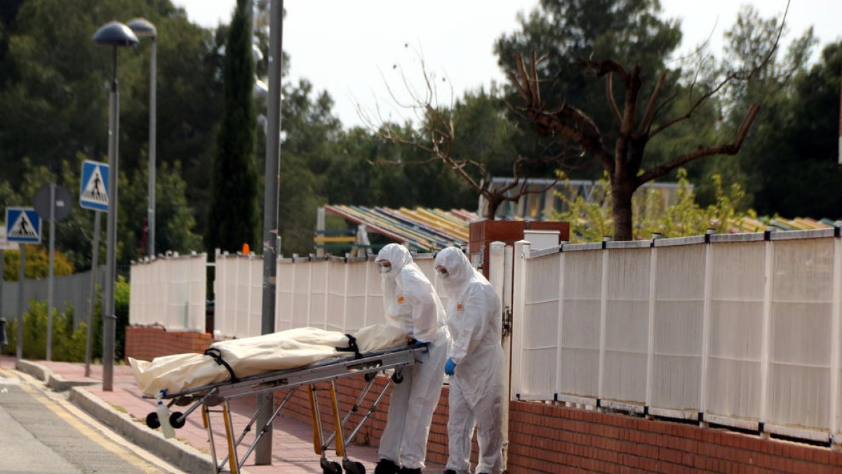 Dos empleats d'una funerària retirant un cadàver de la residència Nostrallar dels Pallaresos.