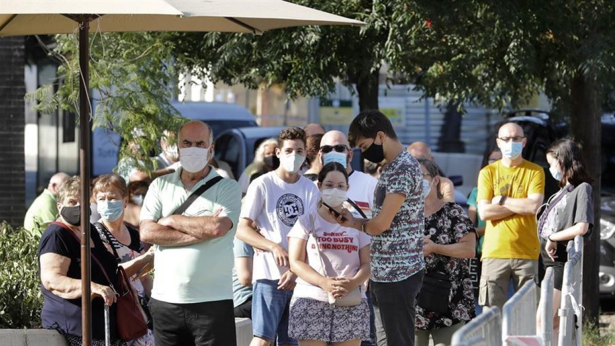 Veïns de Torre Baró acudeixen al Casal del barri per a sotmetre's a les proves PCR promogudes pel Departament de Salut.