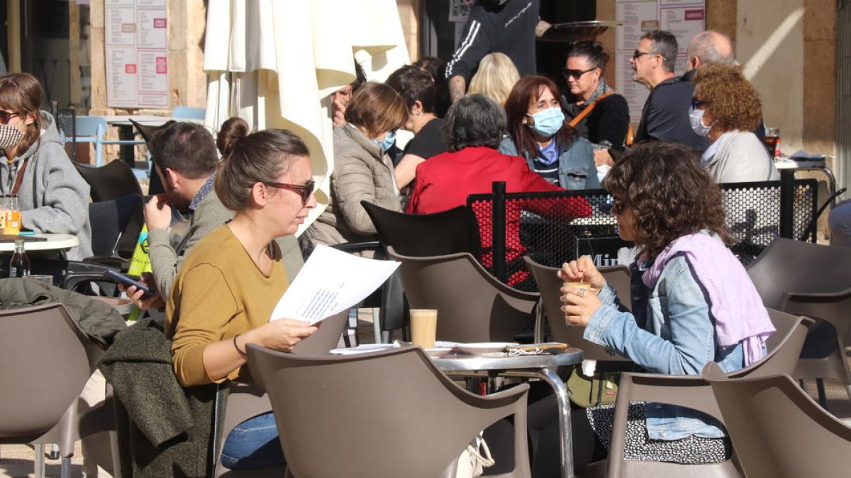 Dues persones en una terrassa d'un bar de la plaça de la Font de Tarragona.