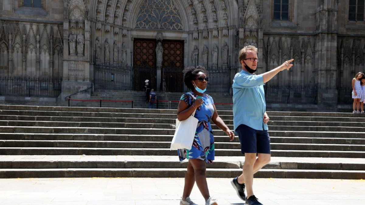 Dos de los pocos turistas que paseaban delante de la catedral de Barcelona.