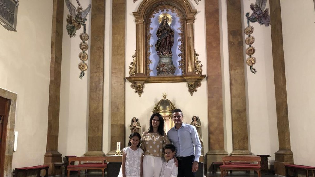 Jorge Orts y Laura Romera, con su hija Carla después de recibir la primera comunión en la parroquia de Sant Francesc de Tarragona.